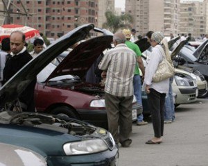 Customers examine car engines in a second-hand lot at the biggest open-air dealership in Cairo